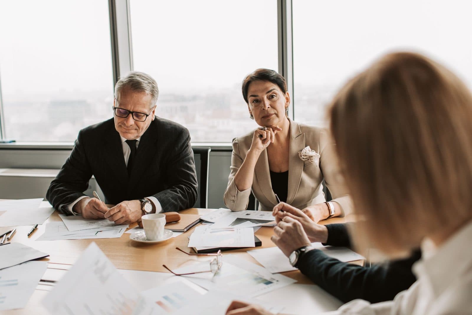 Consultants and a prospective franchise owner reviewing documents around a conference table
